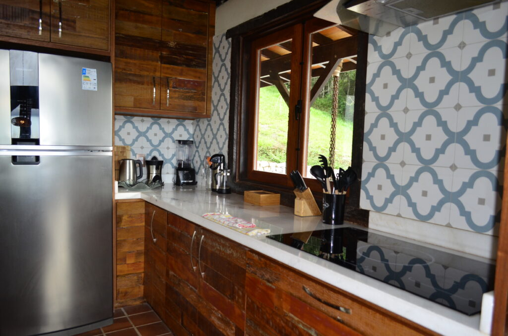 Modern kitchen with cooktop and large windows inside a bioconstruction house in Brazil