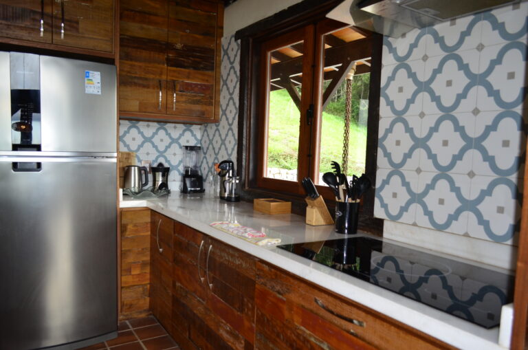 Modern kitchen with cooktop and large windows inside a bioconstruction house in Brazil