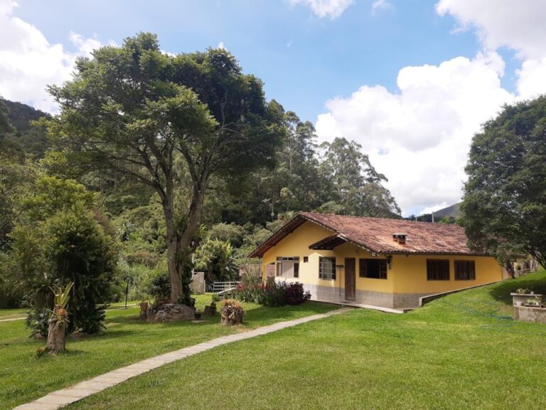 **Alt text:** Waterfall surrounded by lush greenery near the volunteer house at an eco farm.