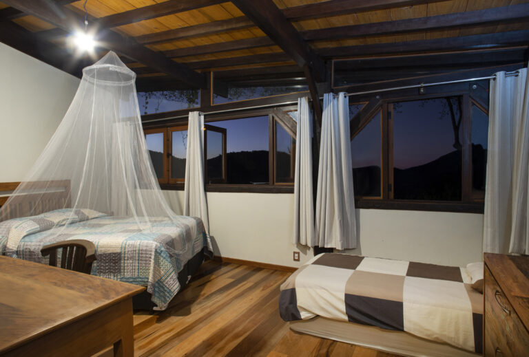 Comfortable bedroom inside a natural building house at Eco Caminhos, Brazil.