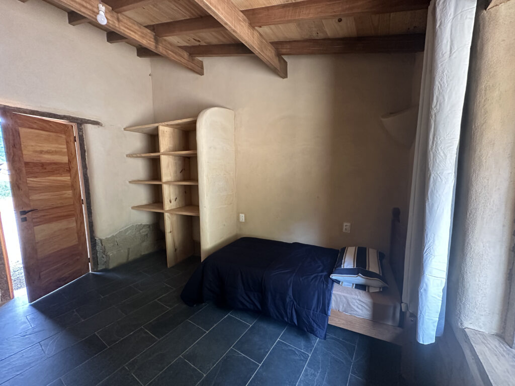 Comfortable bedroom with closet and window inside a bioconstruction house in Brazi