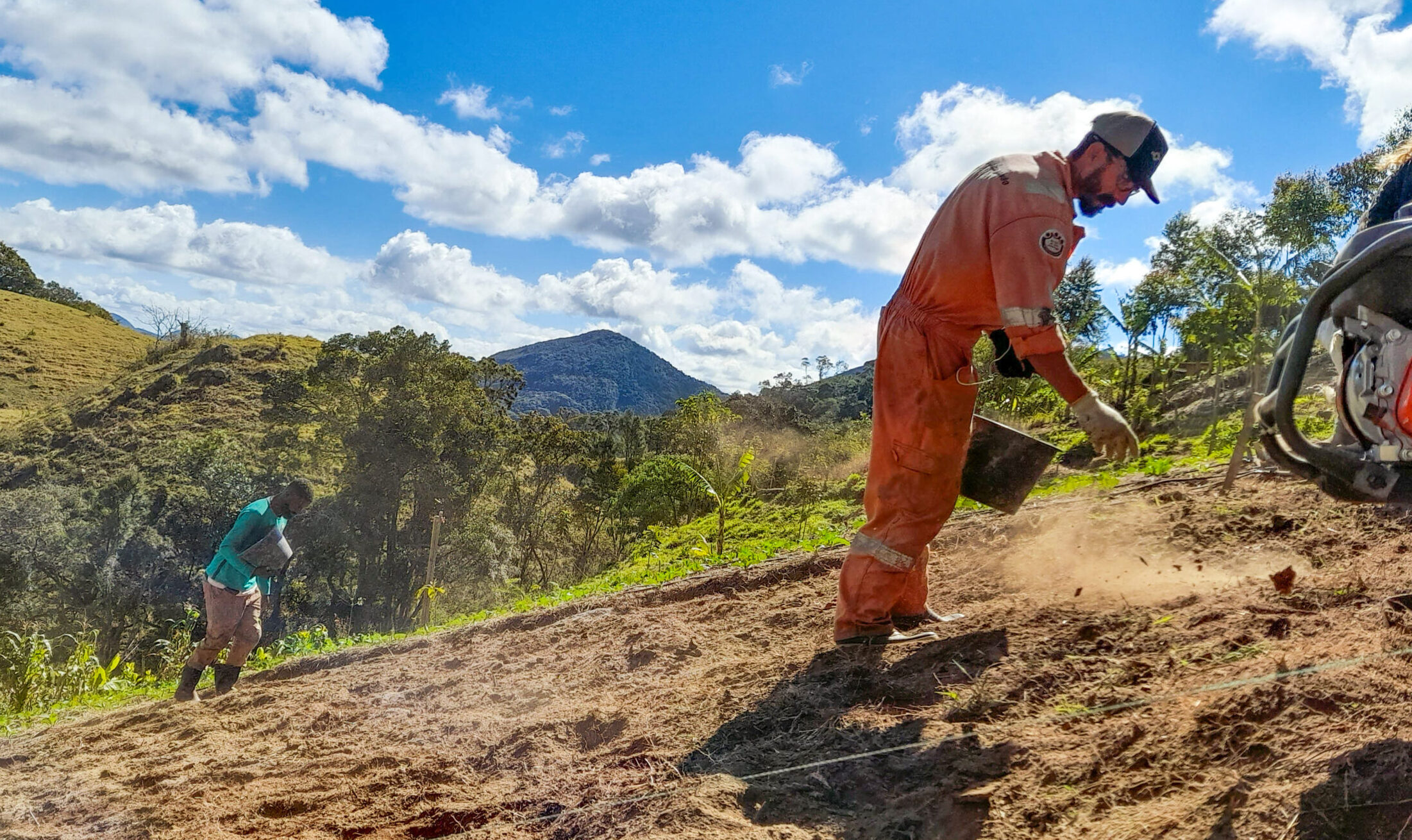 International volunteers preparing fertile soil for planting at a permaculture farm in Brazil.