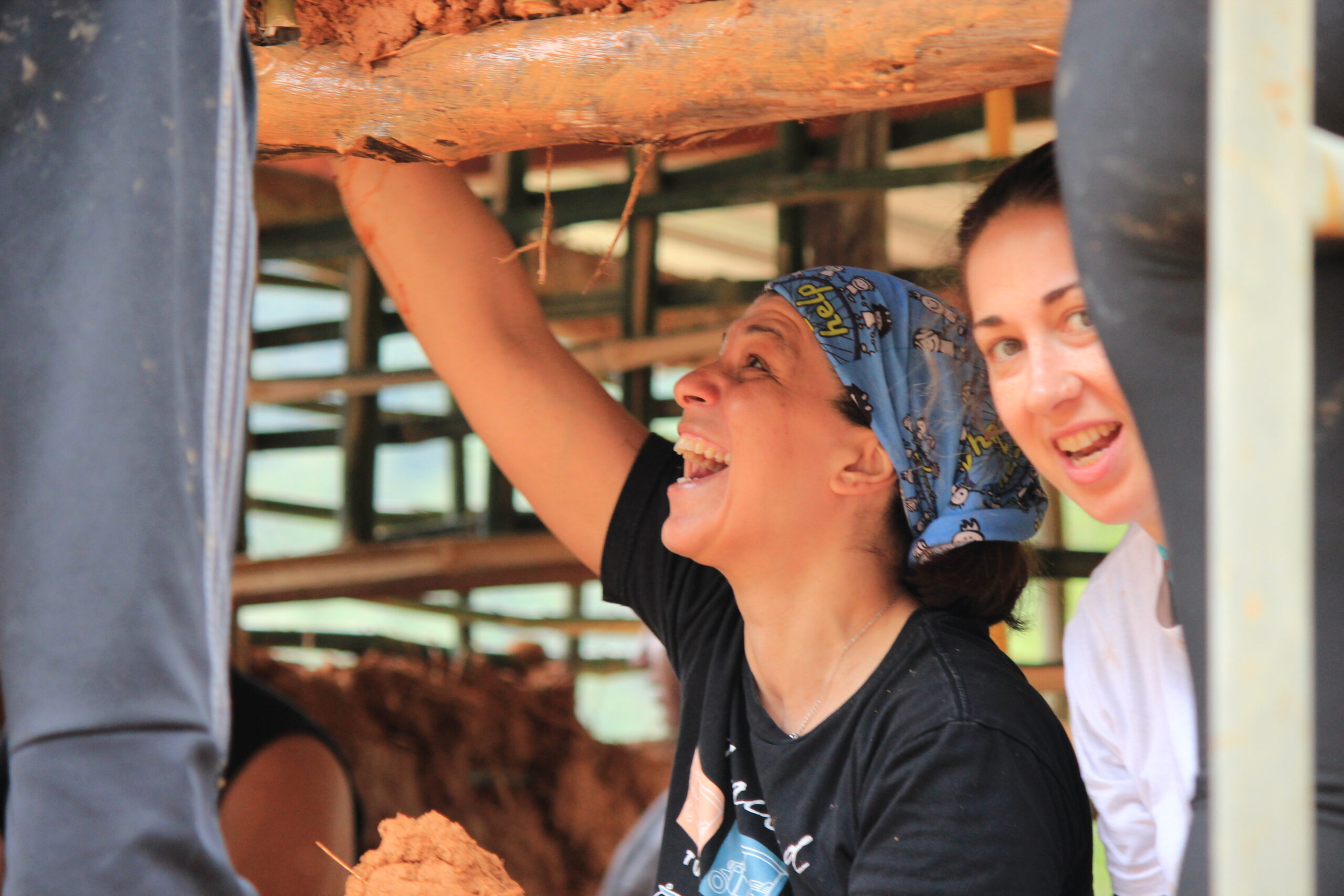 Volunteers building a cob wall using natural materials during a natural building volunteer program in Brazil