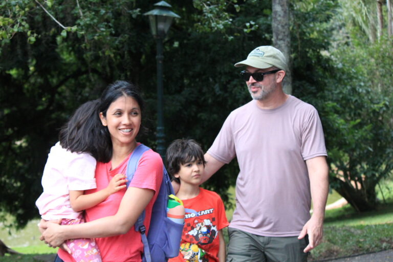 Family walking through a permaculture farm in Brazil during a sustainable living experience surrounded by nature.