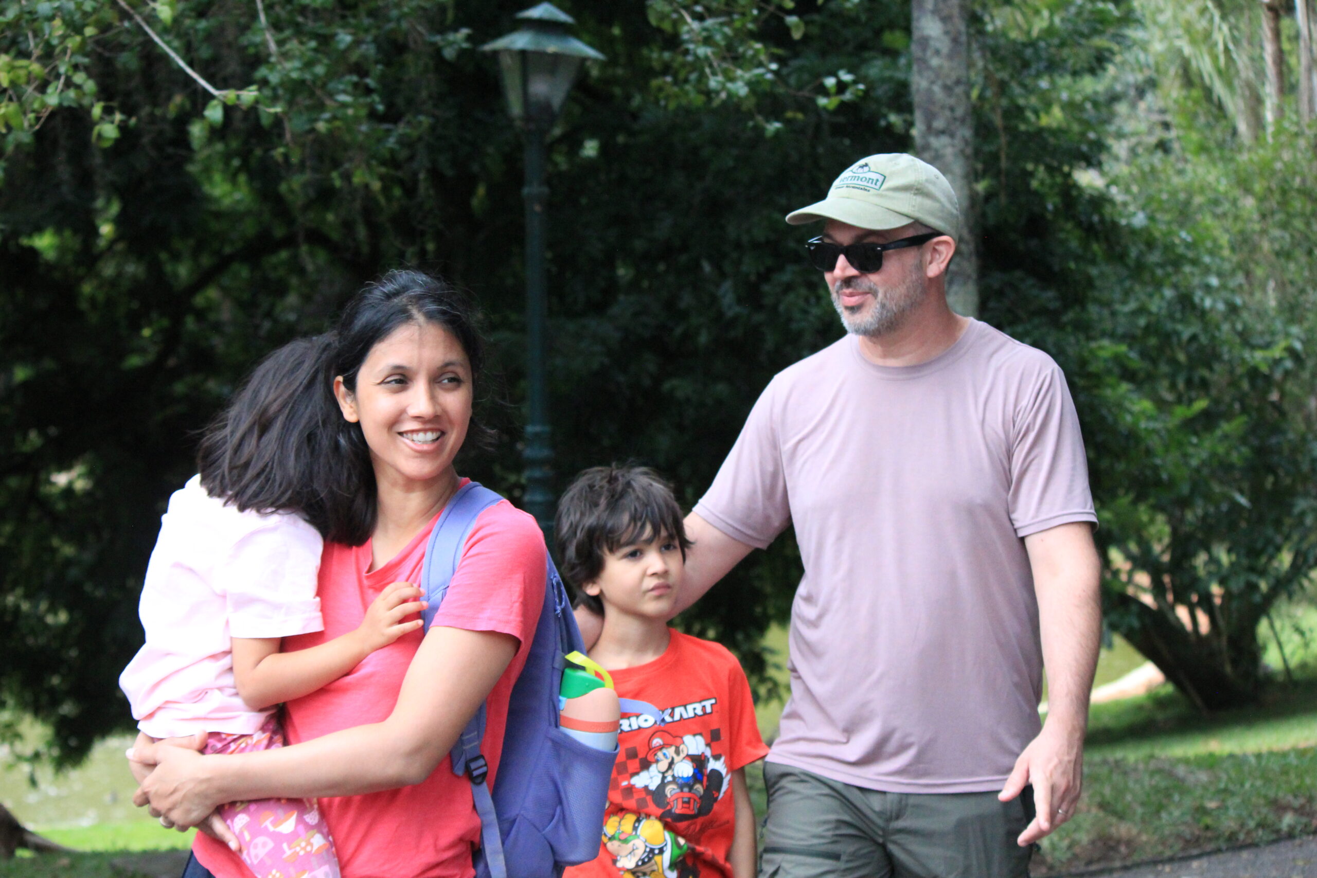Family walking through a permaculture farm in Brazil during a sustainable living experience surrounded by nature.