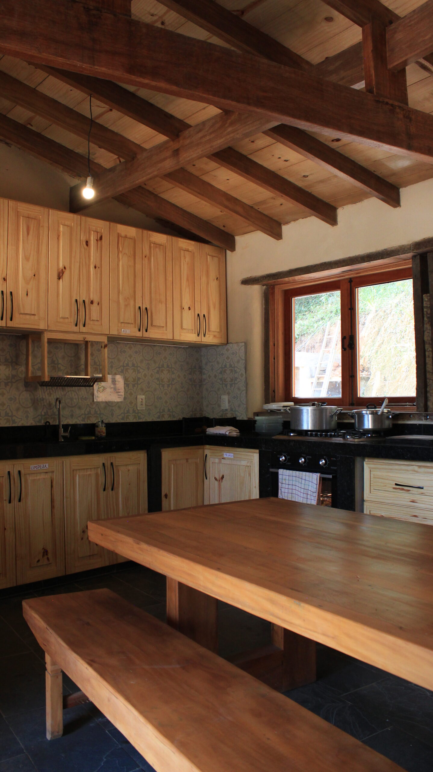 Natural building kitchen with large wooden table inside an eco farm Brazil home