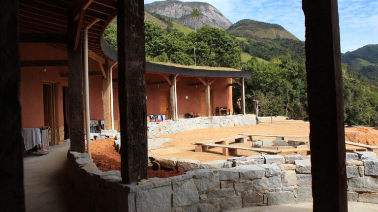 Eco house with grass roof and mountain landscape at a permaculture farm Brazil
