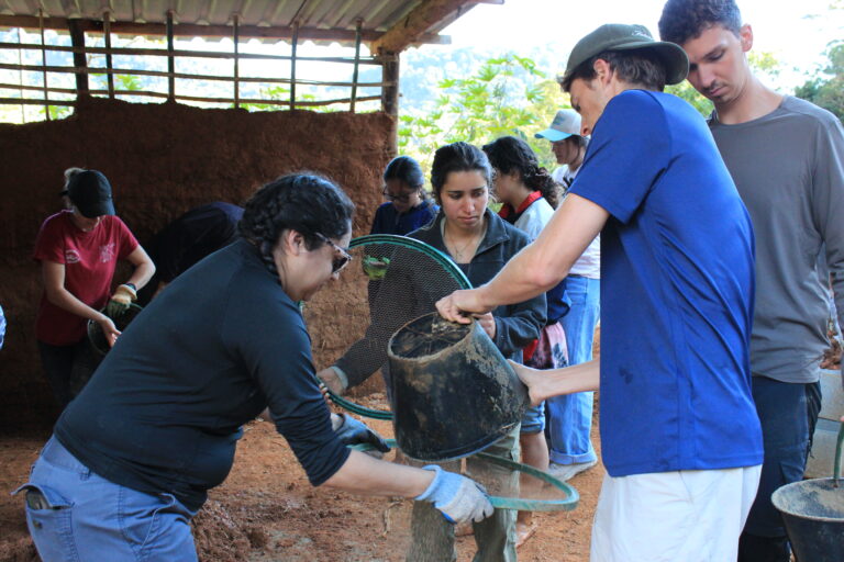 Group participating in a hands-on sustainable farming activity at Eco Caminhos.