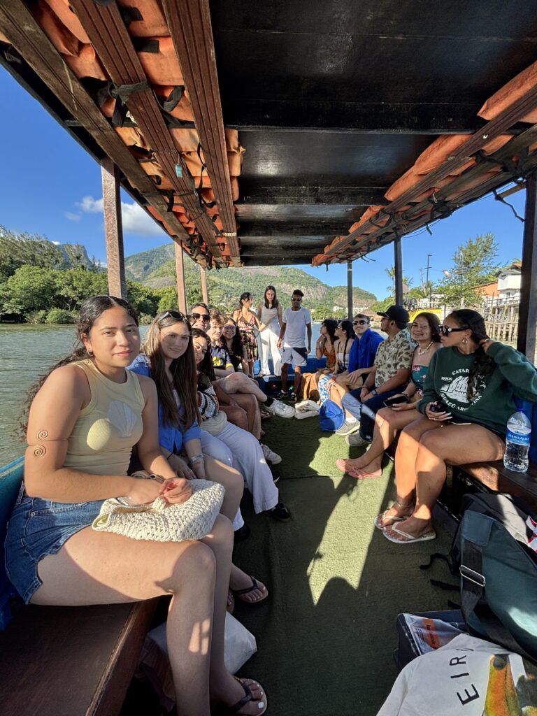 Group enjoying a boat ride with mountains and river landscapes in Brazil.