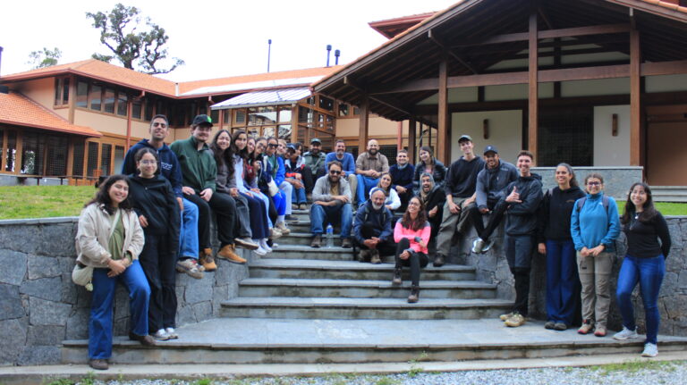 International volunteers gathered on the staircase at the Araçá Project during a sustainability partnership visit in Brazil.