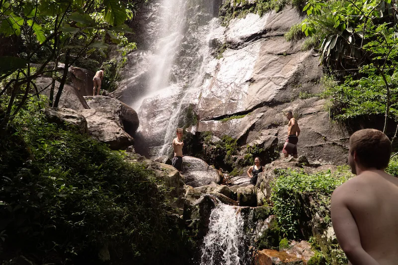 International volunteers enjoying a waterfall during their sustainable living experience in the Brazilian Atlantic Forest.