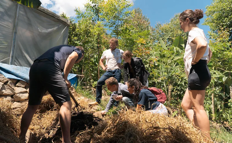 Volunteers producing organic compost on an eco farm in Brazil while learning sustainable agriculture and permaculture techniques.