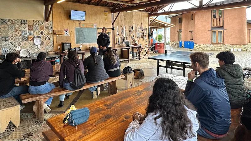 International volunteers attending an educational presentation about permaculture and sustainable living in Brazil.